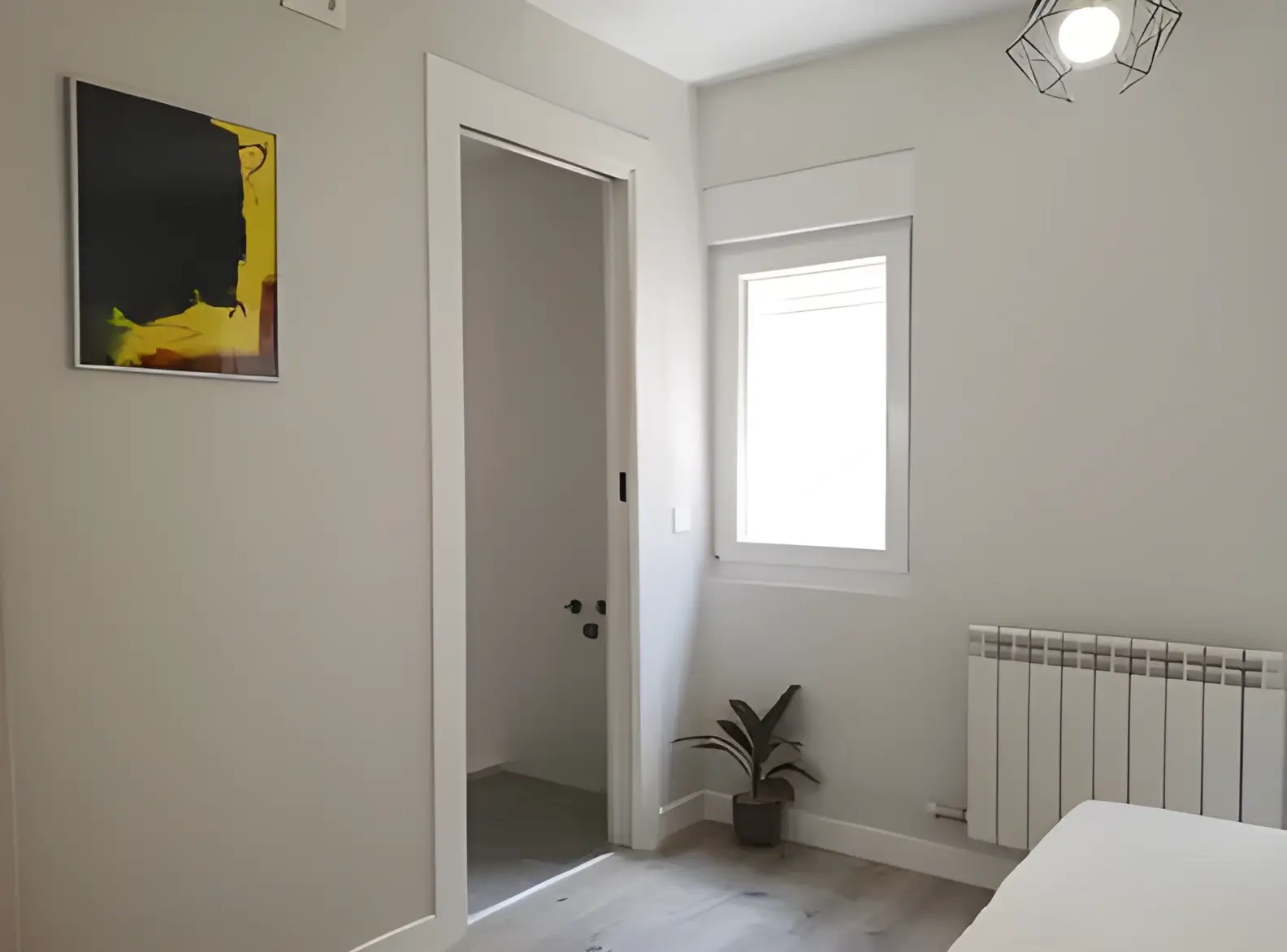 Habitación recién pintada en blanco por Los Pintores en Málaga para comunidad de vecinos
