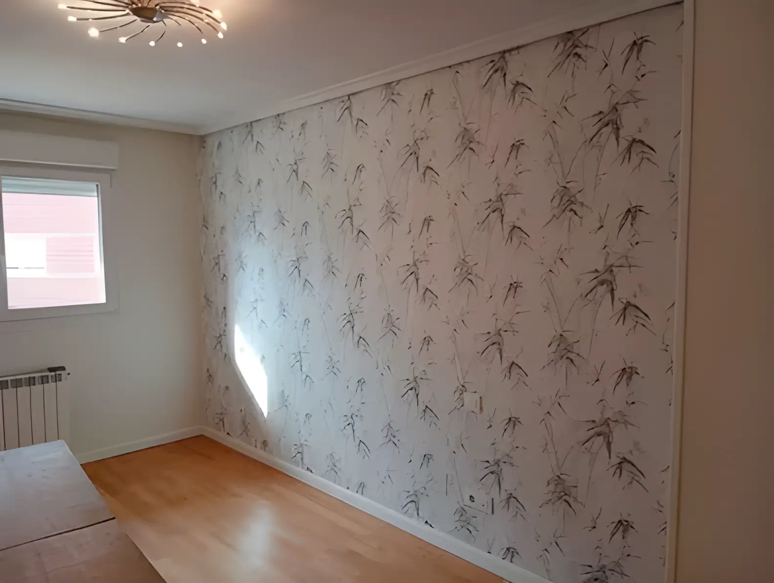 Los Pintores en Málaga colocando papel pintado en pared de acento de habitación luminosa