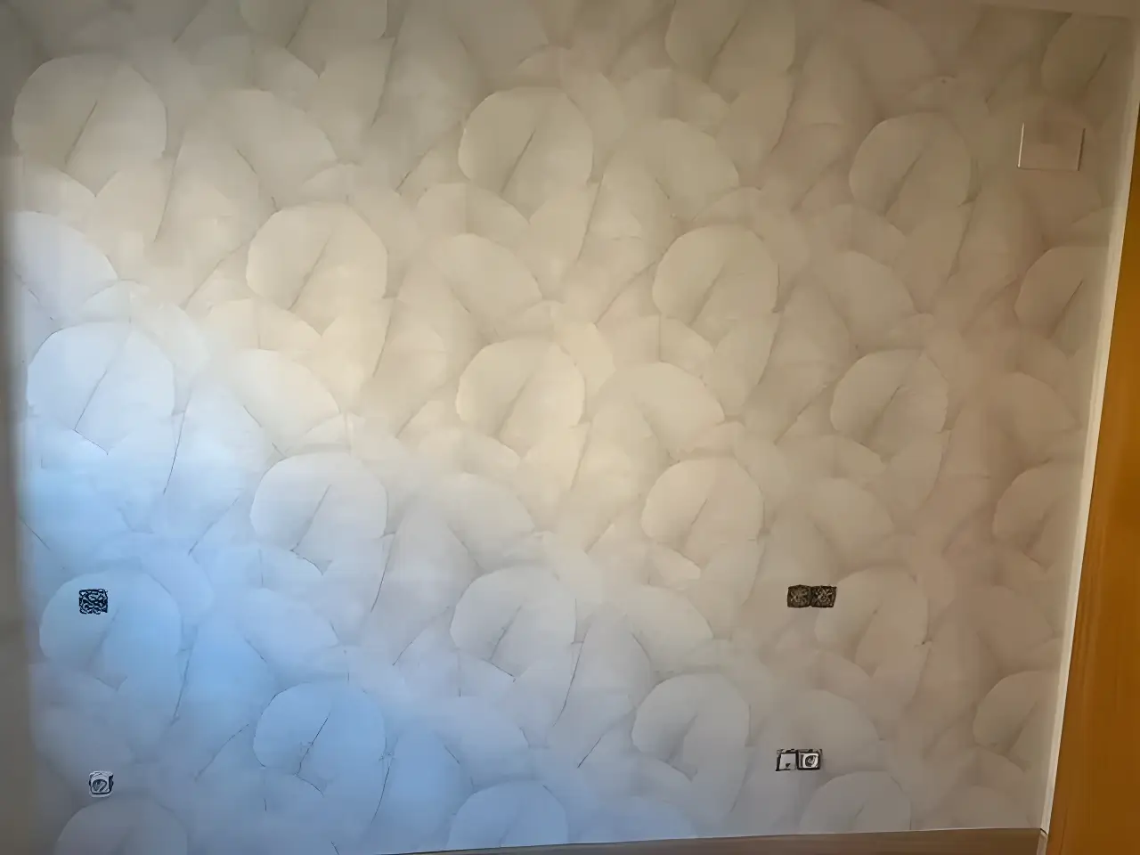 Los Pintores en Málaga aplicando papel pintado de textura clara en salón reformado