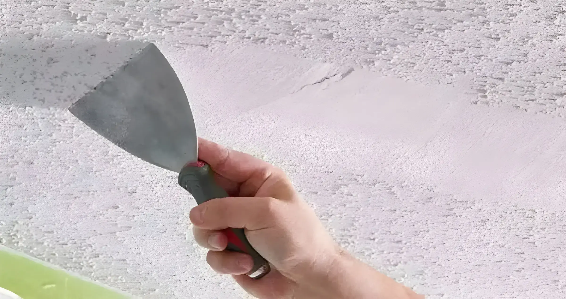 Los Pintores en Málaga eliminando el gotelé con espátula para dejar la pared lisa